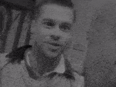 a black and white photo of two men standing next to each other in a doorway .