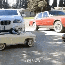 a small toy car is driving down a street next to a larger toy car .