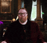 a man with a beard wearing glasses and a red robe