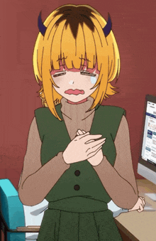 a girl with horns and yellow hair is crying in front of a computer
