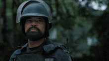 a man with a beard wearing a helmet with the words now make your choice behind him