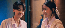 a boy and a girl are standing next to each other and smiling at each other