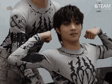 a man flexes his muscles in front of a sign that says ' & team '
