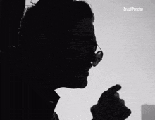 a silhouette of a man wearing sunglasses and a brazil poncho logo