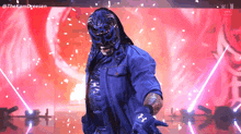 a wrestler in a blue mask is standing in front of a red background