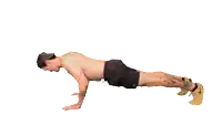 a man without a shirt is doing push ups with his legs crossed