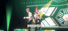 two anime characters are dancing on a stage with the word popupduo written below them