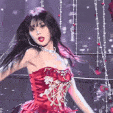 a woman in a red dress with a necklace and hoops
