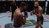 two men are fighting in a boxing ring and one of them is wearing a glove that says ufc