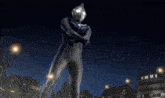 a man in a superhero costume stands in front of a city at night