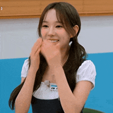 a young girl is clapping her hands and smiling .