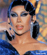 a close up of a woman wearing a blue dress and earrings .