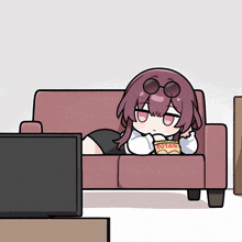 a girl is laying on a couch with a bag of potato chips