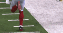 a football player is running on a field with the fox nfl logo in the background .