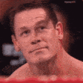 a close up of a man 's face in a boxing ring with a red background .
