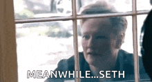 a woman is looking out of a window and saying meanwhile ... seth .