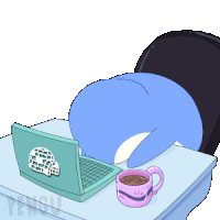 a blue penguin is laying on a desk with a laptop and a cup of coffee