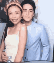 a man and a woman are posing for a picture together .