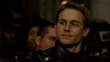 a man in armor is standing in a crowd of people .