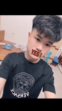 a young man wearing a black t-shirt with the word yes on his face