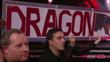 a man is holding a sign that says dragon on it