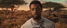 a man in a white shirt is standing in a field with trees in the background and saying `` you were wrong '' .