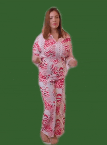a woman in a red and white pajama set is dancing on a green background