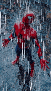 a spiderman is standing in the rain with his arms outstretched