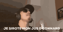a man wearing headphones and sunglasses stands in front of a microphone and says je sirote