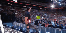 a man in a wrestling ring with a sign that says what on it
