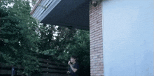 a man standing in front of a brick building