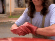 a person wearing red rubber gloves is shaking hands