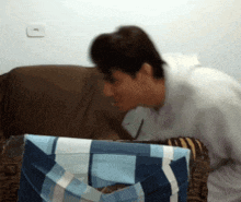 a blurry photo of a person looking at a blue and white plaid pillow