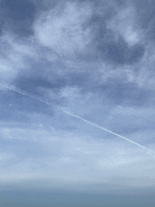 a plane is flying through a cloudy sky