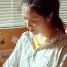 a woman wearing a kodak jacket and a yellow shirt