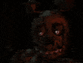 a close up of a person 's face in a dark room with glowing eyes .