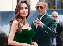 a man in a green suit and a woman in a green dress are standing next to each other