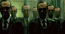 a group of men in suits and ties are standing in a line in the rain .