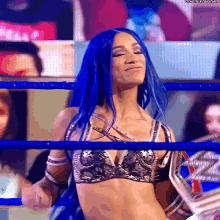 a woman with blue hair is standing in a blue ring