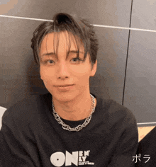 a young man wearing a black shirt that says " en only "