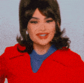 the woman is wearing a red coat and a blue sweater .