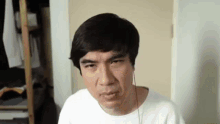 a man wearing headphones is making a funny face while sitting in a room .
