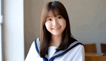 a young woman in a sailor uniform smiles for the camera