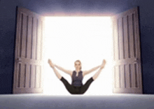a woman is sitting in a yoga pose in front of a door .