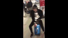 a person sitting on a blue suitcase with the word keek on the bottom right