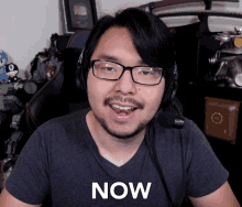 a man wearing glasses and headphones with the word now on his shirt