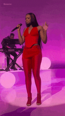 a woman singing into a microphone in front of a keyboard that says kronos on it