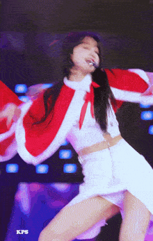 a girl in a santa outfit is dancing on a stage