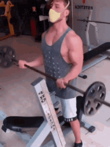 a man wearing a mask lifting a barbell in a gym