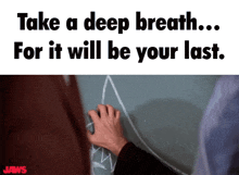 a poster for jaws shows a man drawing on a blackboard